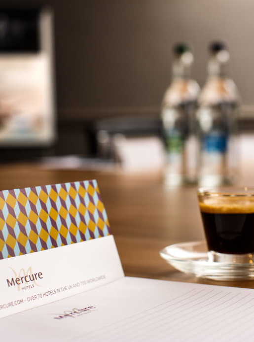 Meeting room table laptop and notepad at mercure hotels