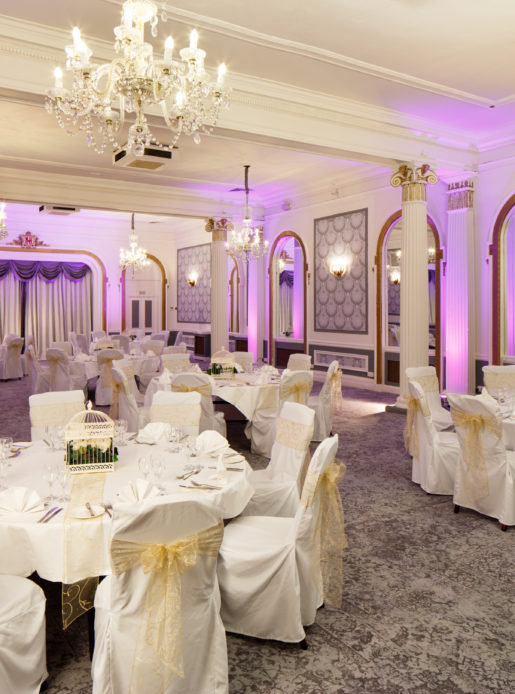 The Ballroom at Mercure Brighton Seafront Hotel arranged for a Wedding Breakfast, white and yellow colour theme, purple lights