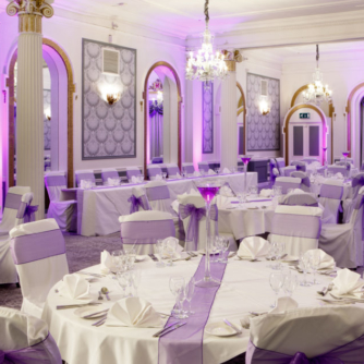 The Ballroom at Mercure Brighton Seafront Hotel arranged for a Wedding Breakfast, white and purple colour theme, purple lights