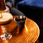 Bartender pouring Espresso Martini on a copper small table at NH Bar at Mercure Brighton Seafront The Norfolk Hotel