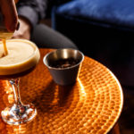 Bartender pouring Espresso Martini on a copper small table at NH Bar at Mercure Brighton Seafront The Norfolk Hotel