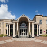 Exterior shot of Mercure York Fairfield Manor Hotel, driveway, columns, potted plants