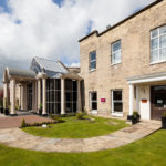 Exterior shot of Mercure York Fairfield Manor Hotel, driveway, columns, potted plants