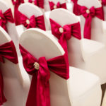 Close up of a dressed chair with a red ribbon prepared for a wedding at mercure hotels